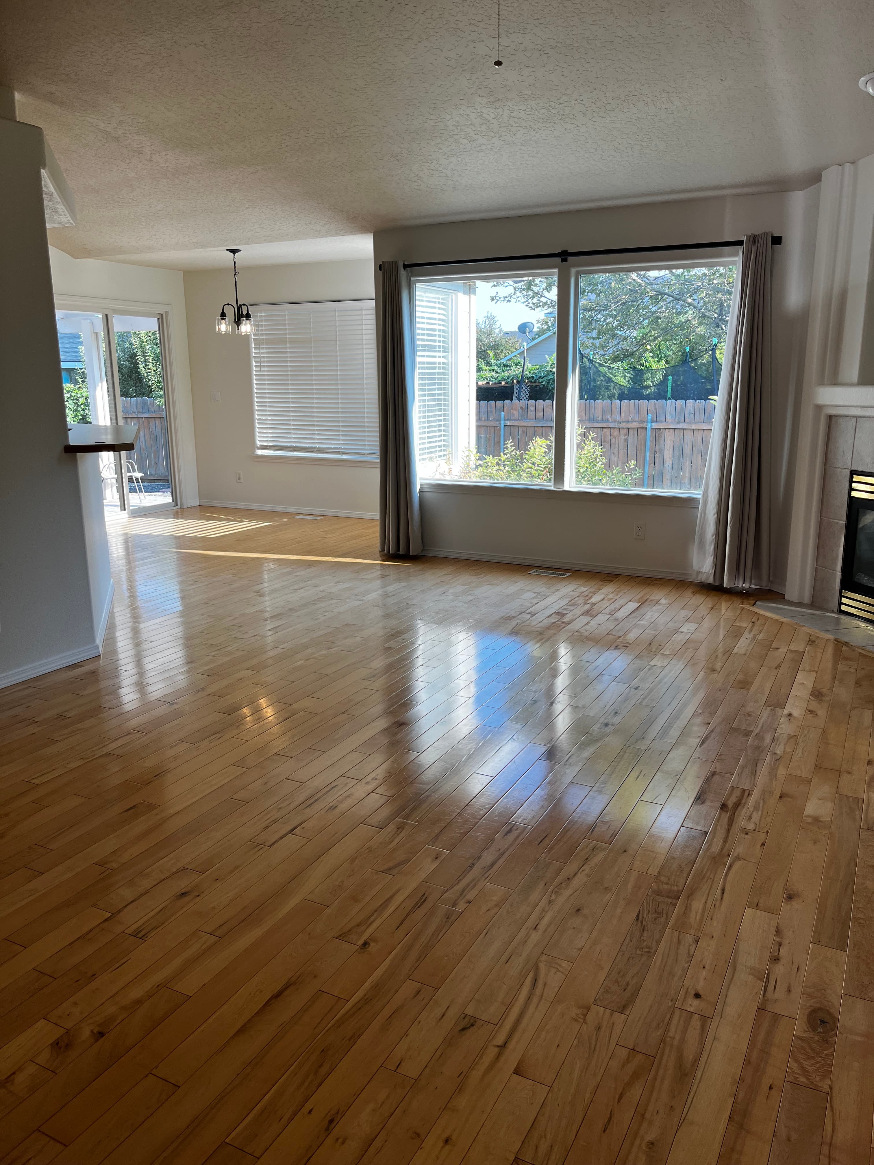 Empty living room with highly polished hardwood floors after a deep clean